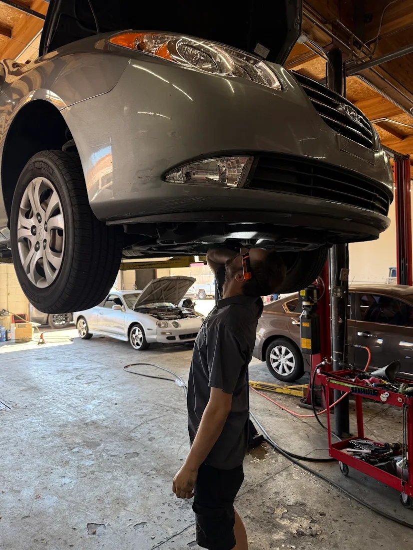 Greasers Automotive technician inspecting a car on a lift